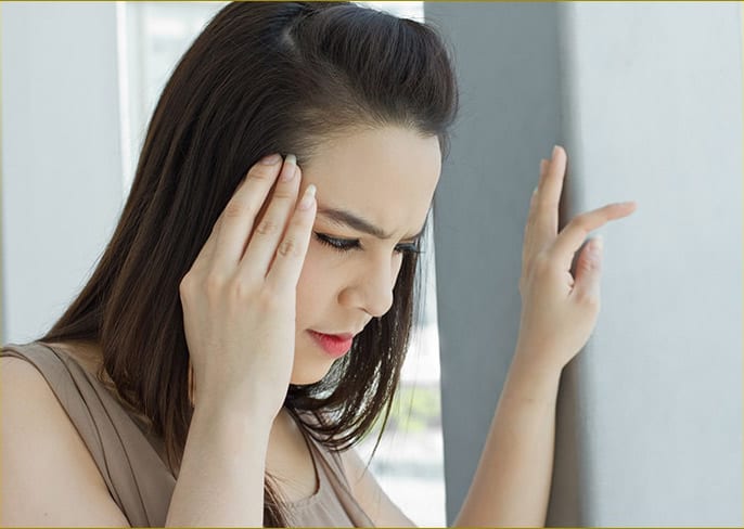 A woman visibly suffering from Tinnitus 